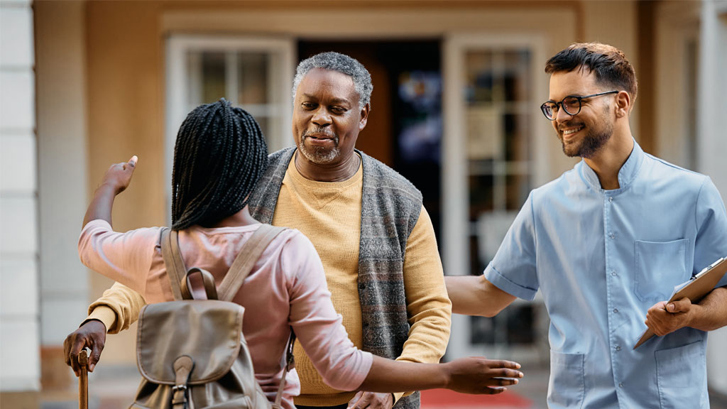 Femme tenant la main de son père âgé dans une chambre d'EHPAD personnalisée à Marseille